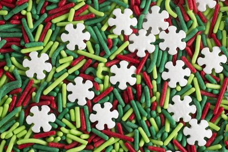 Green and red candy sprinkle decorations, with white snowflake shaped sprinklesの写真素材
