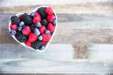 Healthy fresh fruit salad with strawberries, blackberries, blueberries and raspberries. in heart...