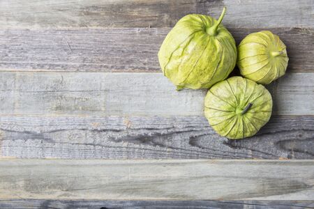 Three tomatillos on wooden surface with copy space.の写真素材