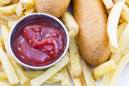 Close up of ketchup with fries and corn dogsの写真素材
