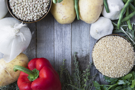 Rustic scene of fresh vegetables, lentils and bulgar wheat with copy space.