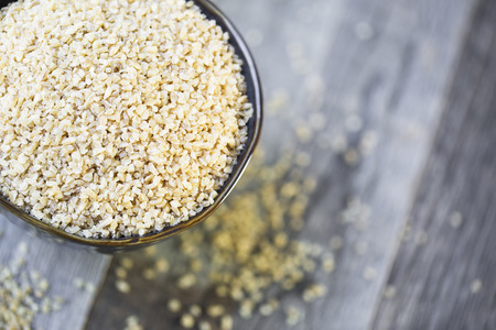 Bowl of dried bulgur wheat in rustic setting.の写真素材