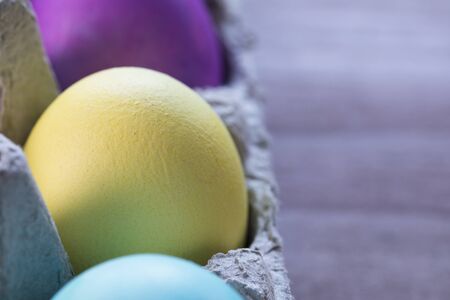 Colorful Easter eggs in egg carton.