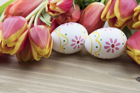 Painted Easter eggs and red and yellow tulips