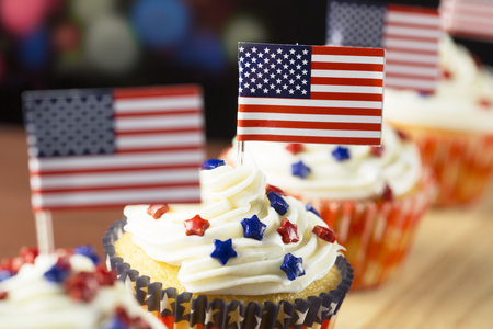 Close up of patriotic cup cake with red white and blue star topping and American flag. Shallow depth of field.の写真素材