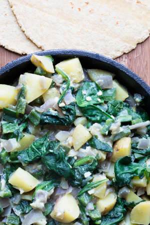 Potato and spinach filling in iron frying pan with corn tortillas, ready for preparation.の写真素材