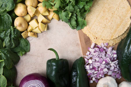 Red onions, poblano peppers, corn tortillas, potatoes, spinach and cilantro; ingredients for vegan tacos.の写真素材