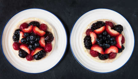 Two mixed berry tarts on plates from aboveの写真素材