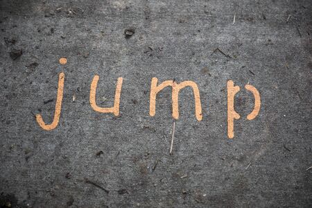The word jump painted on a concrete sidewalkの写真素材
