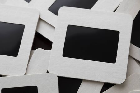 Old slide film transparencies in cardboard frames in pile, close up.の写真素材