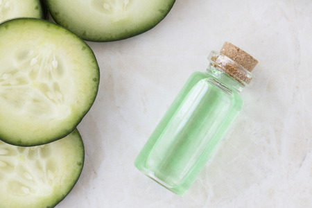 Cucumber slices and small bottle of cucumber extract flat lay.の写真素材