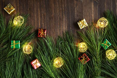 Pine boughs with christmas decorations on wooden surface with copy space.の写真素材