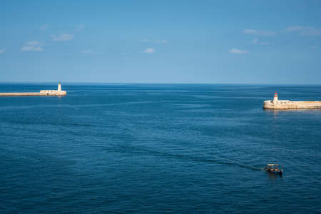 Red and Green Lighthouse (pier light) at the harbour entrance of grand Harbour Valletta Malta. Port entrance breakwater. Horizontal. space for text.のeditorial素材