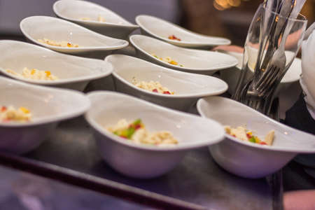 Finger food ready on a dish for party or events on a tray in white bowls with forksの写真素材