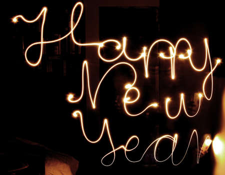 Happy new year made of mobile light natural writing with long exposure shot. dark background...