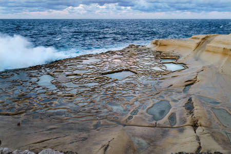 Marsalforn xwejni bay Saltpans salinas in Gozo Malta. at sunset out on a very rough windy day. Landscape shot in winter time November 2017.  while walking in peace and tranquility.の写真素材
