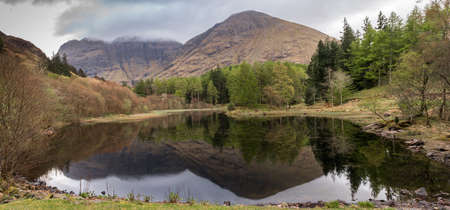 A Lake in scotland in glencoe with reflection of the hillsの写真素材