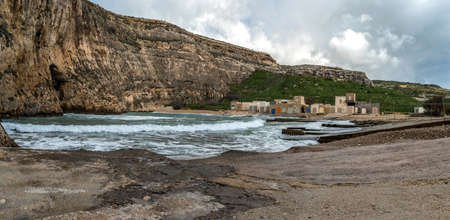 On a bright sunny winter day with rough sea in Dwejra Inland Sea. Cave that connects this little bay to the external Mediterranean clean water.の写真素材
