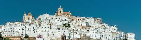 The picturesque old town and citadel of Ostuni, built on top of a hill which is crowned by its cathedral, is located in Puglia, southern Italy, overlooking the Adriatic Seaの写真素材