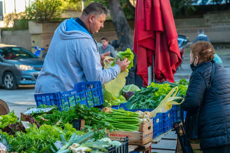 Customers shop for fresh fruit and vegetables on a sunny autumn day at Pula's City market ( Trznica ), Pula, Croatiaのeditorial素材