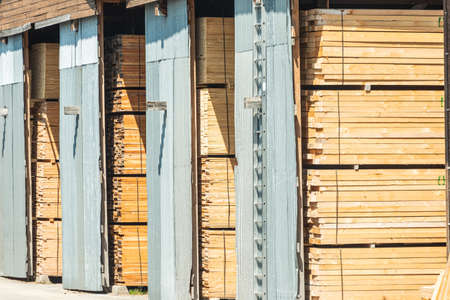 Lots of planks stacked on top of each other in the warehouse. Lumber for further use in...