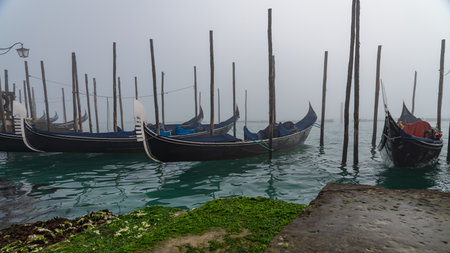 Gondolas moored in Venice, Italy. Foggy day.の写真素材