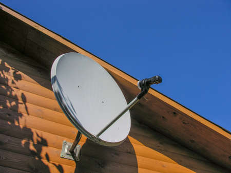 Satellite antenna installed under the roof of a country houseの写真素材