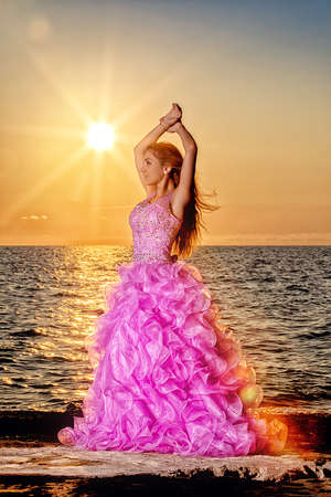 long dress in beautiful sundown at the beachの写真素材