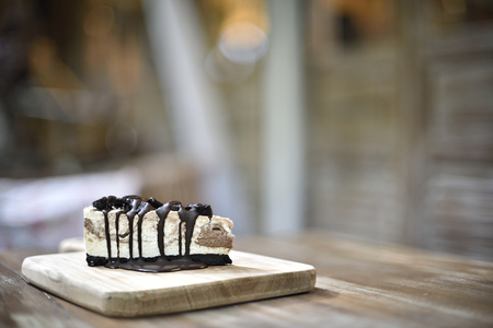 Cream cake with cookies and chocolate syrup on topの写真素材