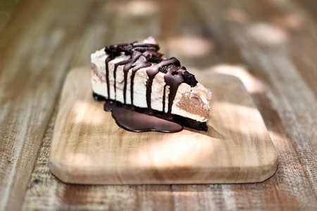 Cream cake with cookies and chocolate syrup on topの写真素材