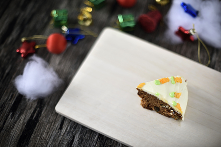 Slice carrot cheese cake on wood plate in christmas backgroundの写真素材