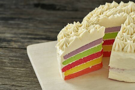Colorful butter cream cake on wood plate slice
