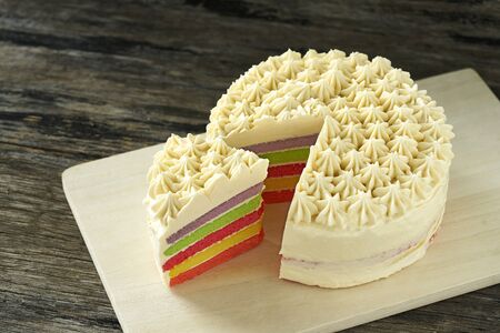 Colorful butter cream cake on wood plate slice