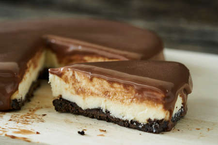 Chocolate cheesecake slice on wood plateの写真素材