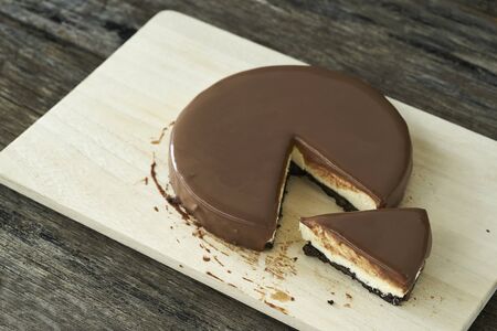 Chocolate cheesecake slice on wood plate