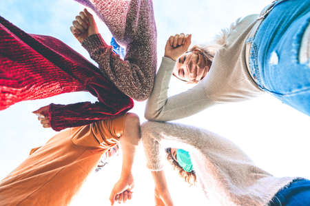 Multiracial young friends bump elbows to say hello in coronavirus time - Concept about avoid the spread of covid-19 - New normal lifestyle concept - Focus on elbowの写真素材