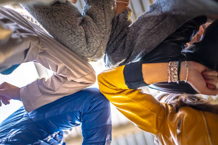 Young millennial friends bump their elbows instead of greeting with a hug - Main focus on elbow - Bottom viewの写真素材