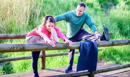 Pregnant woman with a nice smile doing workout exercise, the personal trainer is correcting his posture - Concept about training, fitness, health, trainer routine in prenatal time - Focus on the girlの写真素材