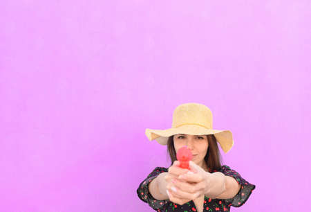 Portrait young beautiful sexy woman with cap, drinks through a straw from a red glass as he makes a winking face - Sexy, joy, concept about happy girl in summer trip - space for advertisingの写真素材