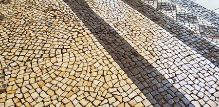 Portuguese street decorated with stones of different shapes and colorsの写真素材