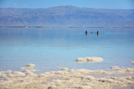 Two tourists floating in the salty Dead Sea waterの写真素材