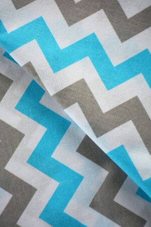 Sky blue, white and grey chevron pattern fabric sample. Folded fabric backgroundの写真素材