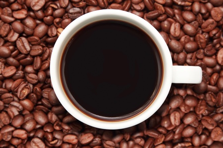 cup of coffee with coffee beans in the background