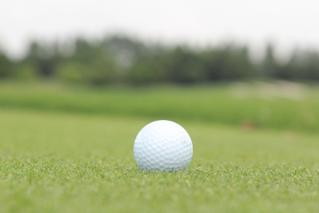golf ball on a green in a sunny dayの写真素材