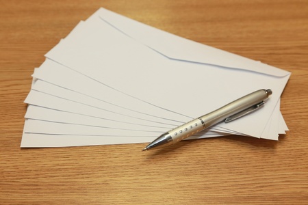 envelopes with a pen on a wooden tableの写真素材