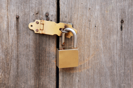 closed metal door lock on a wooden doorの写真素材