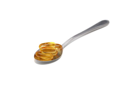 isolated fish oil on a spoonの写真素材