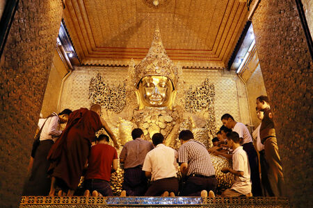 MANDALAY -MAY  25: The Myanmar people venerated Buddha statue with the golden paper at Mahamuni Buddha temple, May 25, 2013 in Mandalay, Myanmar.のeditorial素材
