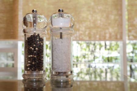 pepper and salt shakers on the wooden tableの写真素材