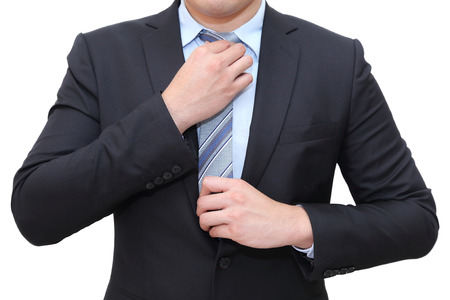 isolated businessman in suit tying the necktieの写真素材